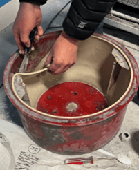 peeling latex solids out of basket for landfill disposal